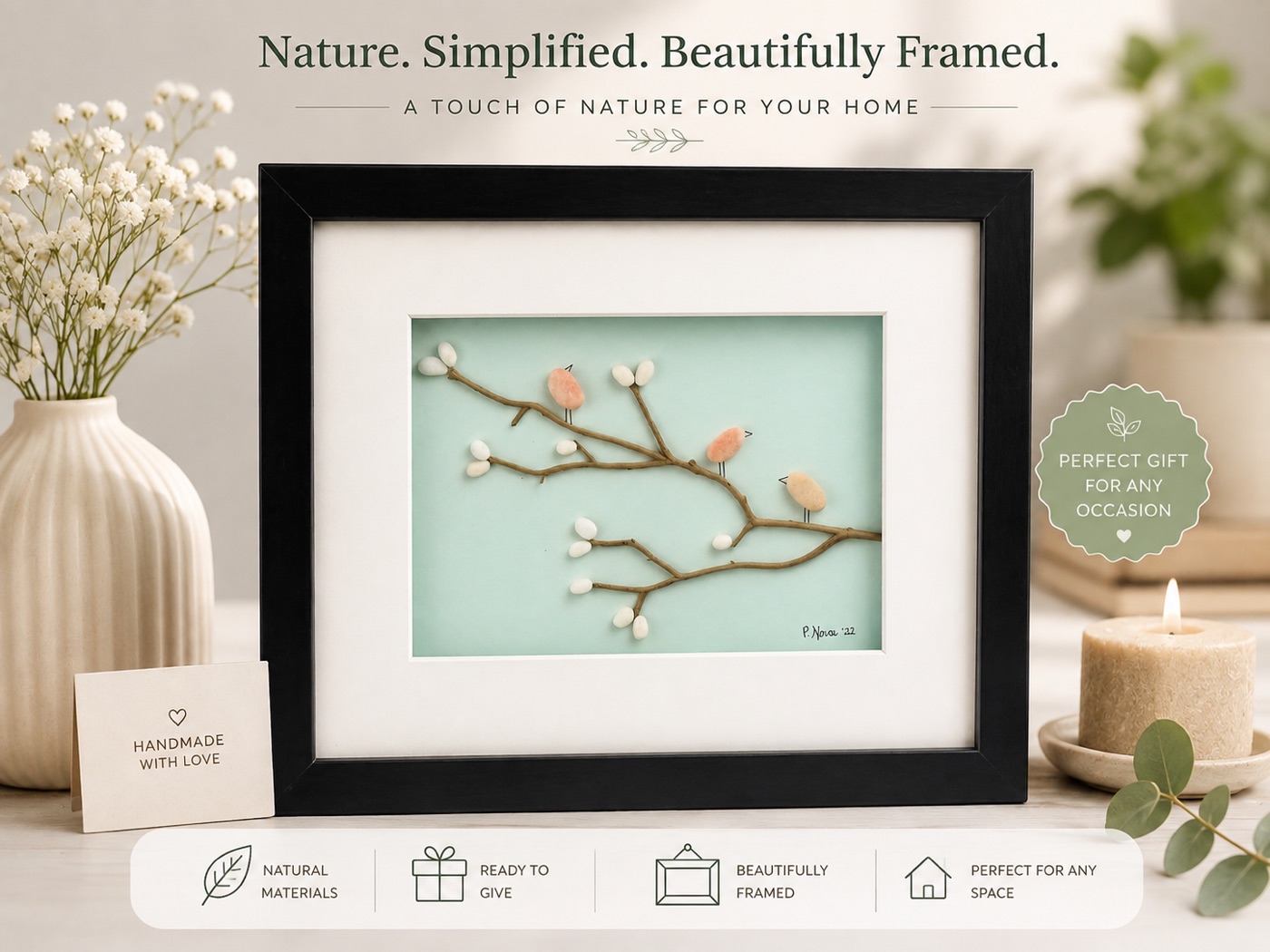 Framed pebble art of three peach-toned birds on a branch against a mint green background.