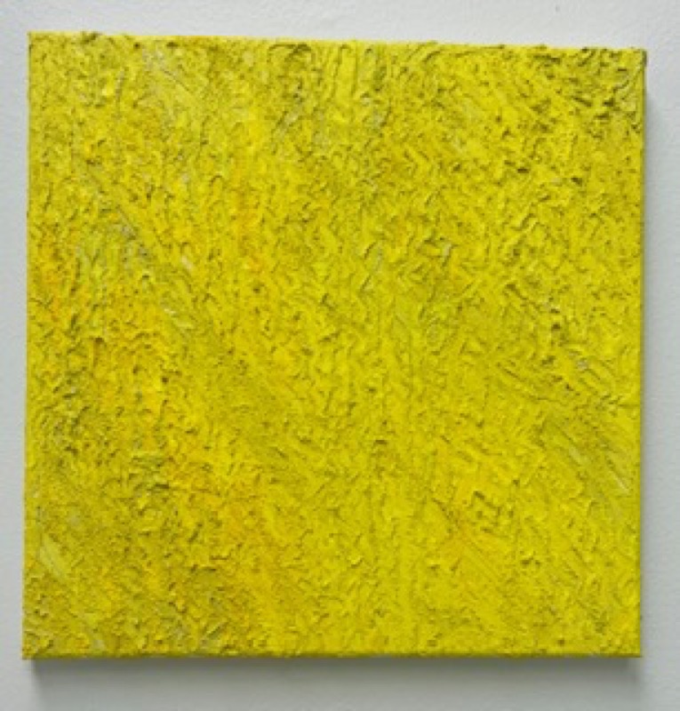 A square, heavily textured abstract painting in bright yellow, mounted on a white wall.
